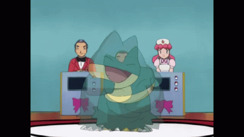 A Man In A Tuxedo And A Woman In A Pink Dress Are Behind A Frog GIF