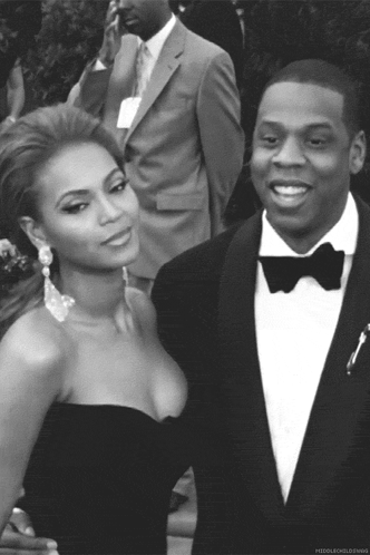 A Man In A Tuxedo And A Woman In A Strapless Dress Pose For A Photo GIF