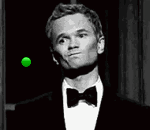 A Man In A Tuxedo And Bow Tie Is Looking At A Green Ball In The Air . GIF