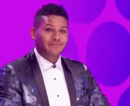 A Man In A Tuxedo And Bow Tie Is Making A Funny Face On A Purple Background . GIF