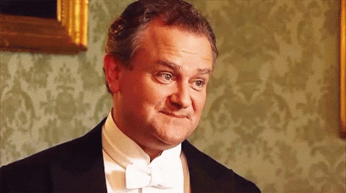 A Man In A Tuxedo And Bow Tie Is Making A Silly Face . GIF