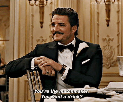 a man in a tuxedo and bow tie is sitting in a chair and talking to someone .