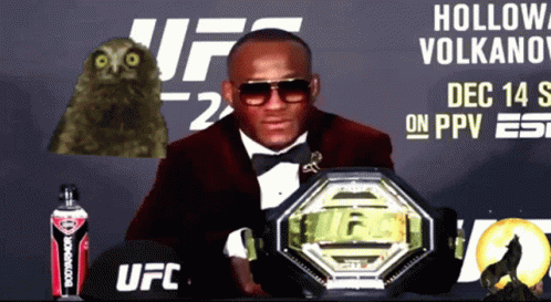 A Man In A Tuxedo Holding A Ufc Belt GIF
