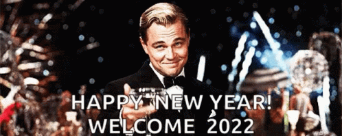 A Man In A Tuxedo Is Pointing At The Camera With The Words Happy New Year Welcome 2022 Below Him GIF