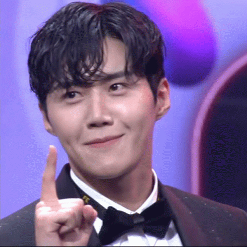A Man In A Tuxedo Is Pointing Up With His Index Finger GIF