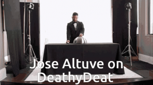 A Man In A Tuxedo Is Standing Behind A Table With The Words Jose Altuve On Deathy Deat Written On It GIF