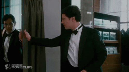A Man In A Tuxedo Is Standing In Front Of A Mirror With The Word Movieclips On The Bottom Right GIF