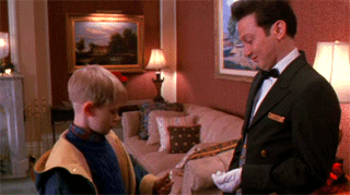 A Man In A Tuxedo Is Standing Next To A Boy In A Living Room GIF