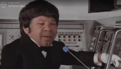 A Man In A Tuxedo Is Talking Into A Microphone With The Words Made With Reface App On The Bottom GIF