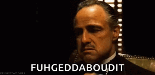 A Man In A Tuxedo Is Talking On A Cell Phone And Says Fuhgeddaboutit . GIF