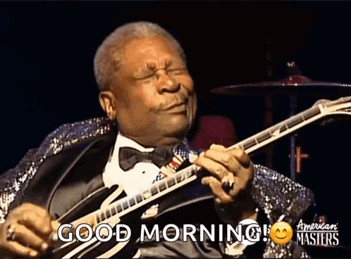 a man in a tuxedo playing a guitar with the words good morning on the bottom