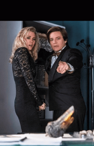 A Man In A Tuxedo Pointing At A Woman In A Black Lace Dress GIF