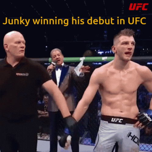 A Man In A Ufc Shorts Holds The Hand Of Another Man GIF