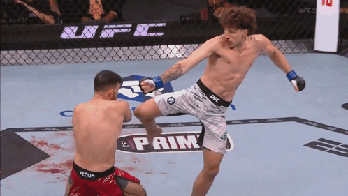 A Man In A Ufc Shorts Kicking Another Man In Red Shorts GIF