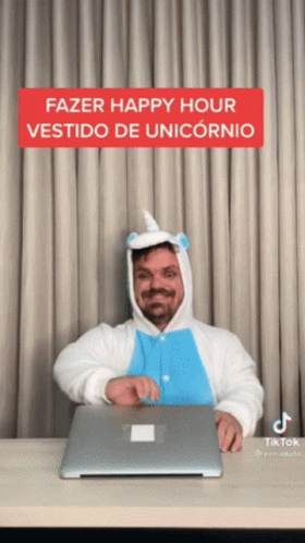A Man In A Unicorn Costume Is Sitting At A Desk With A Laptop GIF