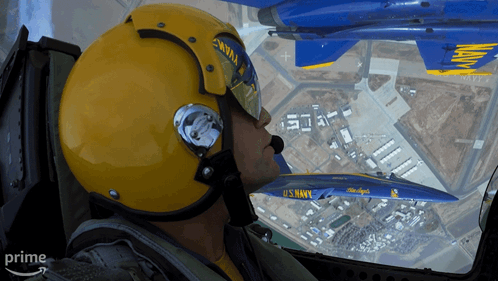 A Man In A Us Navy Helmet Looks Out The Window Of A Plane GIF