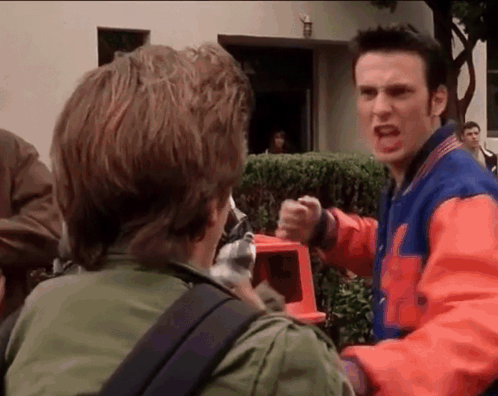 A Man In A Varsity Jacket Is Yelling At Another Man . GIF