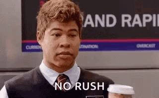 A Man In A Vest And Tie Is Holding A Cup Of Coffee And Saying `` No Rush '' . GIF