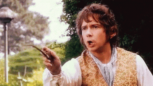 A Man In A Vest Is Holding A Stick In His Hand And Making A Funny Face . GIF