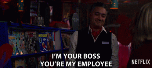 a man in a vest says " i 'm your boss you 're my employee " in front of a shelf of magazines