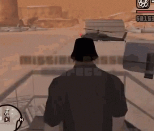 A Man In A Video Game Is Standing In Front Of A Mission Base Sign GIF