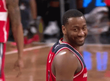 A Man In A Washington Wizards Jersey Is Smiling GIF
