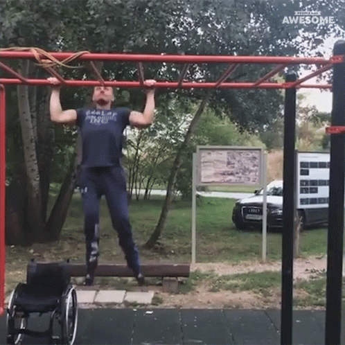 A Man In A Wheelchair Is Doing Pull Ups On A Bar GIF