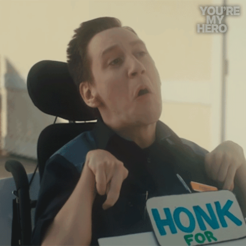 A Man In A Wheelchair Is Holding A Sign That Reads Honk For GIF