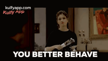 A Man In A Wheelchair Is Sitting On A Couch In A Living Room And Says `` You Better Behave '' . GIF