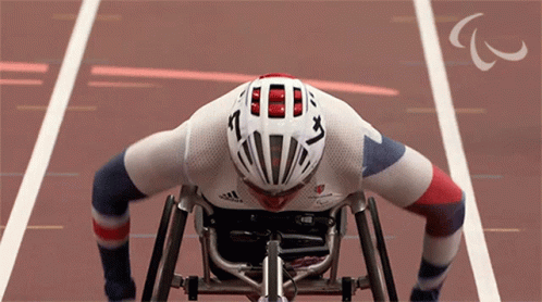 A Man In A Wheelchair Wearing A Helmet That Says ' A ' On It GIF