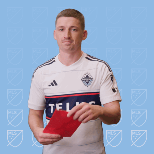 A Man In A White Adidas Shirt Holds A Red Card In His Hand GIF