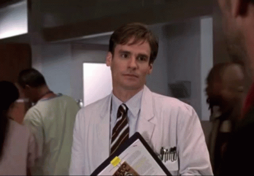 A Man In A White Coat And Tie Holds A Clipboard With A Yellow Sticker That Says ' A ' On It GIF