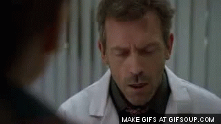 A Man In A White Coat And Tie Is Talking To Another Man In A Black Shirt . GIF