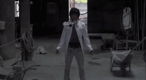 A Man In A White Coat Is Standing In A Dark Room With His Arms Outstretched And A Red Light Coming Out Of His Chest GIF