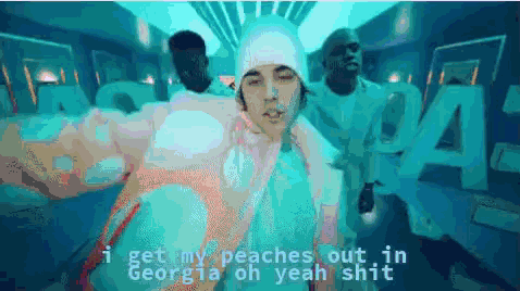 A Man In A White Hat Is Standing In Front Of A Sign That Says Georgia GIF