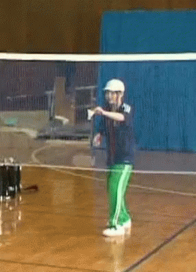 A Man In A White Hat Is Standing In Front Of A Volleyball Net GIF