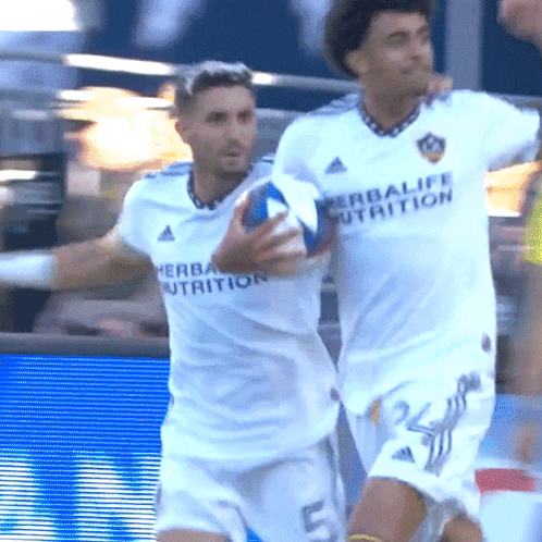 A Man In A White Herbalife Nutrition Jersey Holds A Ball GIF