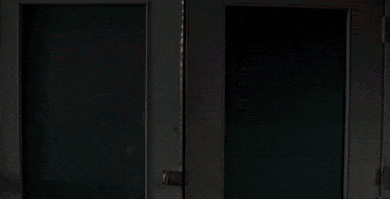A Man In A White Hoodie Is Looking Out A Window GIF