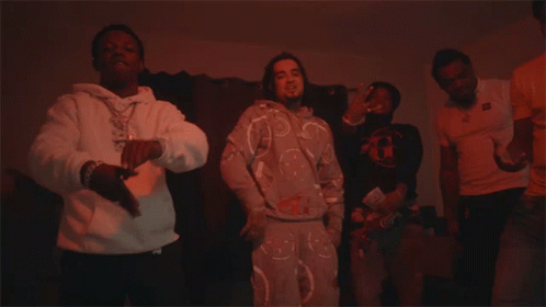 A Man In A White Hoodie With A Necklace That Says ' Snoop Dogg ' On It Is Dancing GIF