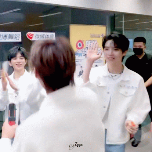 a man in a white jacket is giving a high five