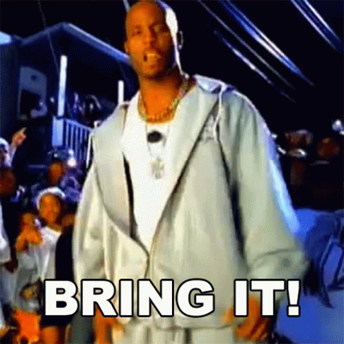A Man In A White Jacket Is Standing In Front Of A Crowd With The Words Bring It Written On The Screen GIF