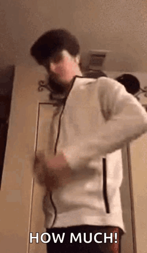 A Man In A White Jacket Is Standing In Front Of A Door And Saying How Much . GIF