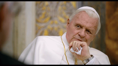A Man In A White Robe Holds A Piece Of Paper To His Face GIF