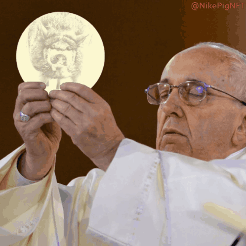 A Man In A White Robe Is Holding A Piece Of Paper With A Picture Of A Dog On It GIF