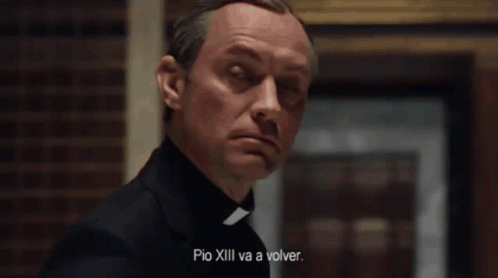 A Man In A White Robe Is Sitting In A Chair With The Words " Quien Es El Papa Ahora " Written On The Bottom GIF