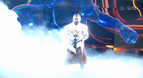 A Man In A White Robe Is Standing In A Foggy Room In Front Of A Large Screen . GIF
