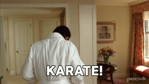 A Man In A White Robe Is Standing In A Room And Says Karate GIF