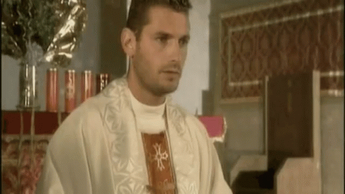 A Man In A White Robe With A Red Cross On His Chest GIF