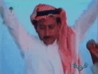 A Man In A White Shirt And A Red Scarf Is Dancing With His Arms Outstretched . GIF