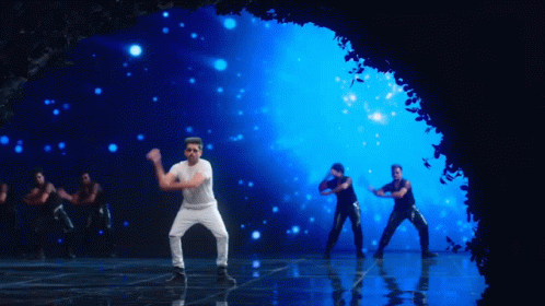 A Man In A White Shirt And Black Pants Is Dancing On A Stage GIF